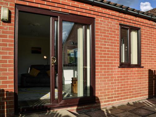 een glazen schuifdeur op een stenen muur bij Keepers Retreat, The Annex in Roughton