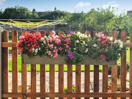 een houten hek met een doos bloemen erop bij Keepers Retreat, The Annex in Roughton