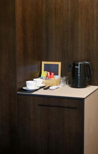 a counter with a coffee pot and dishes on it at Hotel resort Sedula in Skogalis