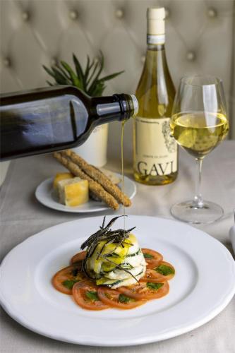 a white plate of food with a glass of wine at Best Western Air Hotel Linate in Segrate
