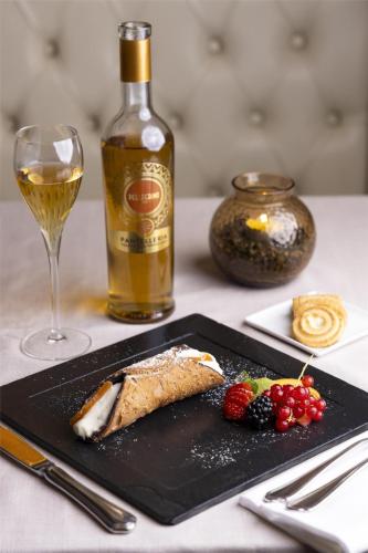 a plate of food and a bottle of wine on a table at Best Western Air Hotel Linate in Segrate