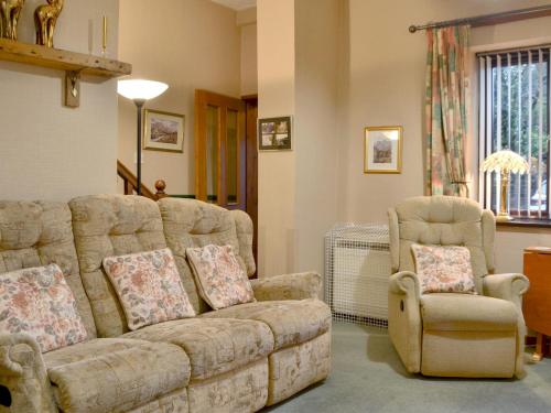 a living room with a couch and a chair at Printers Cottage in Ambleside
