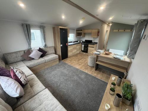 a large living room with a couch and a table at 8 Guests - Swimming Pool - 1min to the Beach in Heacham