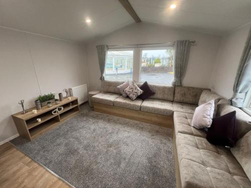 a living room with a couch and a large window at 8 Guests - Swimming Pool - 1min to the Beach in Heacham