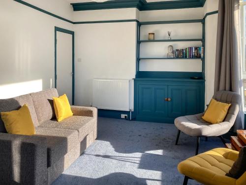 a living room with a couch and yellow pillows at Blue Sands in Morecambe