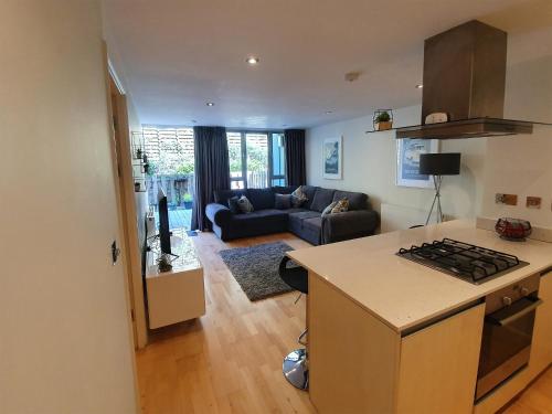 a kitchen and living room with a stove top oven at Apartment 4, Zinc in Newquay