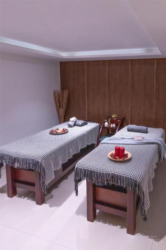 two beds in a room with two tables with food on them at Levatio Suites Muscat, a member of Radisson Individuals in Muscat