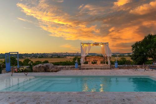 an outdoor wedding venue with a wedding arch and a pool at La Maison - Tenuta Colavecchio in Putignano