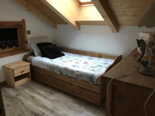 une chambre avec un lit dans une pièce avec des plafonds en bois dans l'établissement Gite Le sommet, à Sallanches