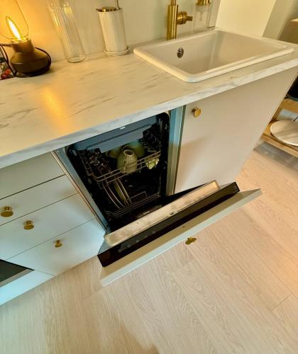 a cabinet in a kitchen with a sink at Ula seaview suite in Larvik