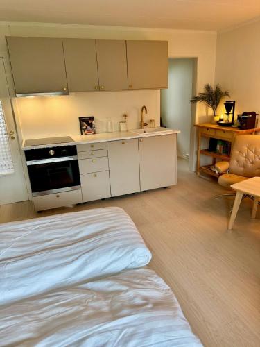 a kitchen with white cabinets and a stove top oven at Ula seaview suite in Larvik