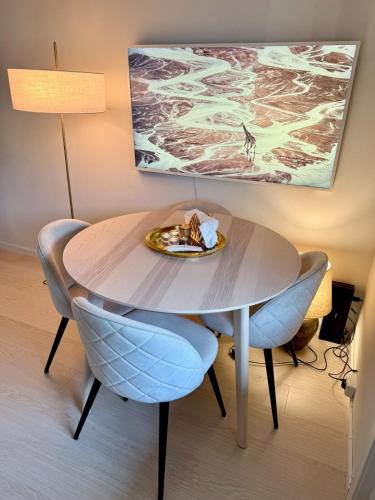 a table with two chairs and a plate of food on it at Ula seaview suite in Larvik