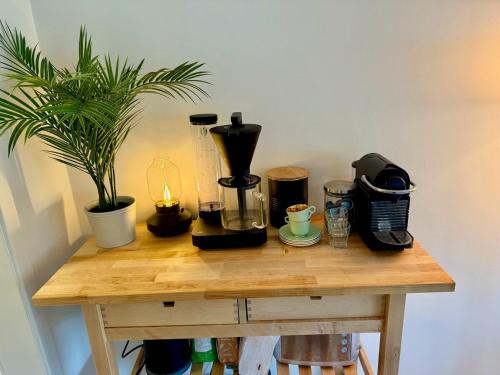 a wooden table with coffee makers and a plant on it at Ula seaview suite in Larvik