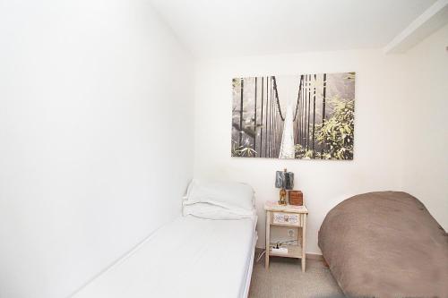 une chambre avec un lit et un tableau au mur dans l'établissement Ma Vie, à Mandelieu-la-Napoule