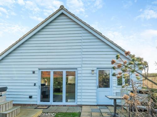 a white house with a window and a table at The Annexe At Park Farm Barns - Uk39379 in Snettisham