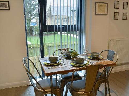 a dining room table with chairs and a table and a window at Alnwick Malthouse in Alnwick