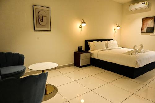 a hotel room with a bed and a chair at Hotel S S International Coorg in Suntikoppa