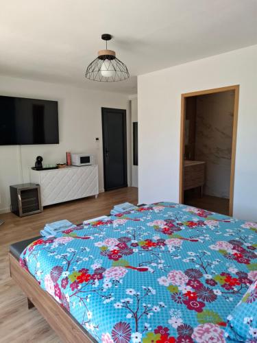 a bedroom with a large bed with a blue comforter at La suite de la route des vins in Arsac