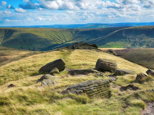 a grassy hill with rocks on top of it at Middlecroft - Uk45062 in Tideswell