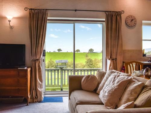 un salon avec un canapé et une grande fenêtre dans l'établissement Mount Cottage, à Wennington