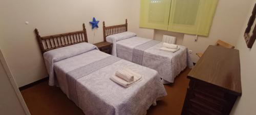 a room with three beds with towels on them at Granja de San Antonio in Fresnedillas