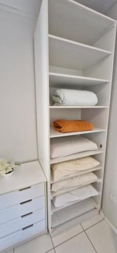 a white closet with white shelves and towels at Apto Inteiro em Atibaia do lado da Av Lucas Bairro Nobre in Atibaia