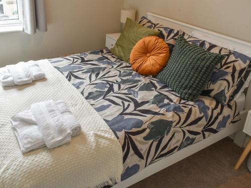 a bed with towels and pillows on it at Russell Retreat in Skipton