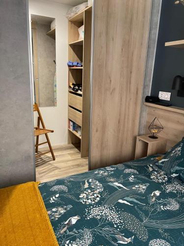 une chambre avec un lit avec une couette verte dans l'établissement Mobil home dans camping le domaine de soulac siblu, à Soulac-sur-Mer
