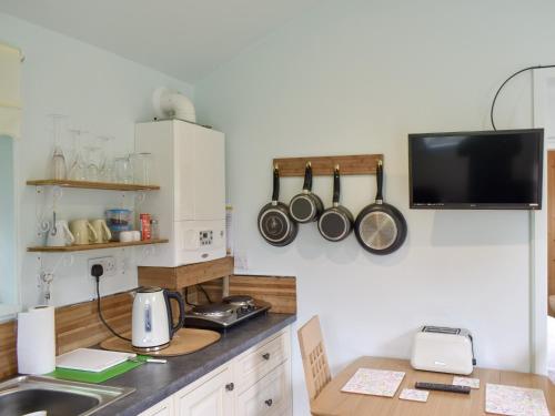 a kitchen with a counter with pots and pans on the wall at Shepherds Hut 3 At Laddingford - Uk32532 in Yalding