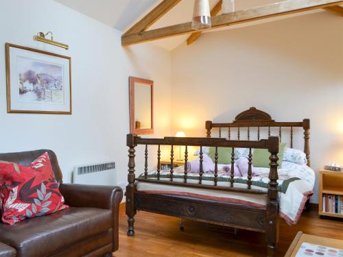 a living room with a bed and a couch at Gardeners Cottage in Near Sawrey