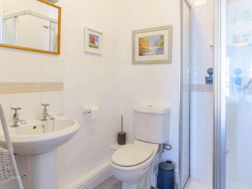 a white bathroom with a toilet and a sink at 3 bed in Freshwater East FB100 in Hodgeston