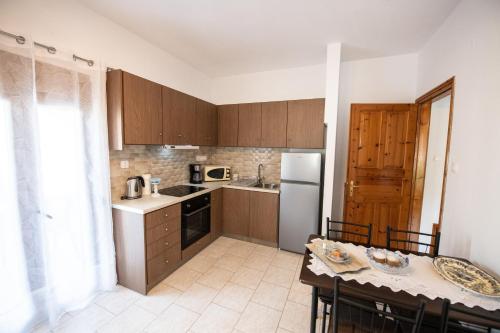 a kitchen with wooden cabinets and a table with chairs at Zisi's Home in Neo Klima