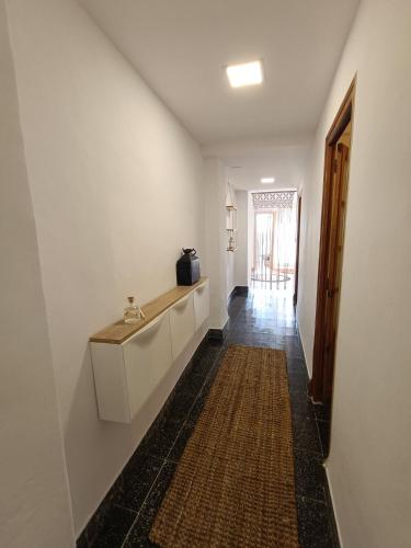 a hallway with a white wall and a counter and a hallway sidx sidx at La casita del tío tomas in Montanejos