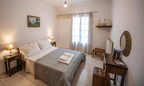 a bedroom with a bed and two tables and a window at Zisi's Home in Neo Klima