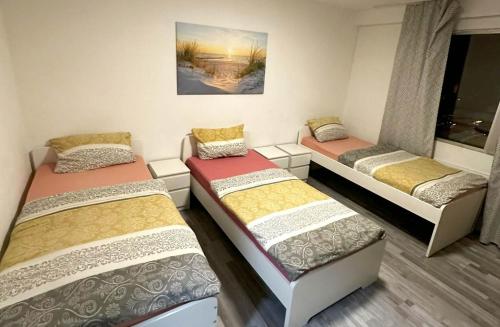 three beds in a room with a window at Workers Apartment Duisburg in Duisburg