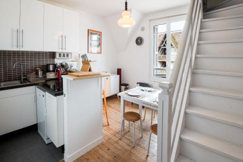 une cuisine avec un escalier et une table dans une pièce dans l'établissement DUPLEX villa ancienne, 59 m2 , vue mer et plein centre!, à Villers-sur-Mer