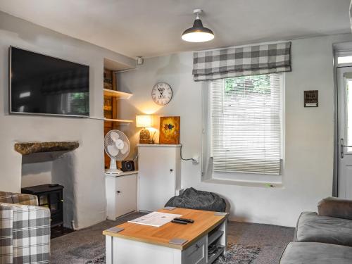 a living room with a couch and a table at Beeswax Cottage in Dalton in Furness