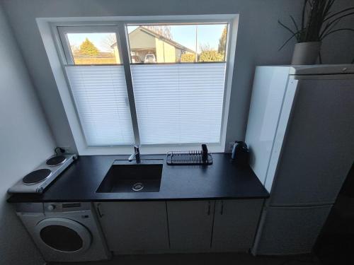 a small kitchen with a sink and a window at Cozy villa apartment close to everything in Hørning