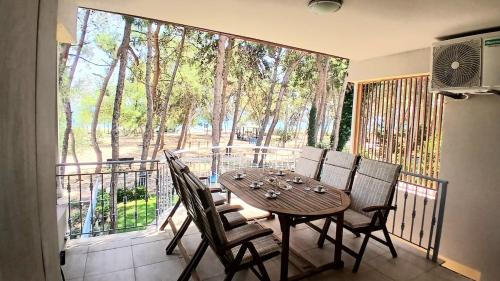 a table and chairs on a balcony with a view of trees at Vila Irida in Nea Makri