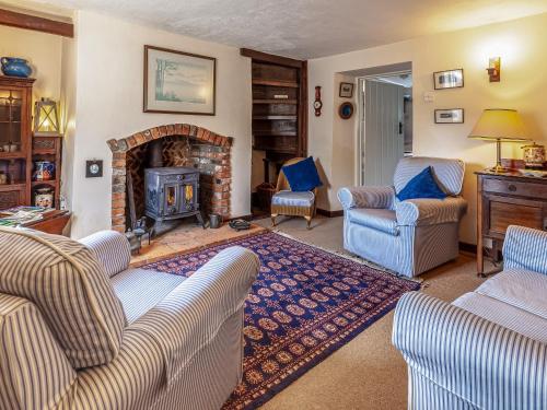 a living room with two couches and a fireplace at Colbridge Cottage in Docking