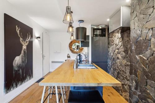 une cuisine avec un évier et un mur en pierre dans l'établissement KAZA BELLA Les Carroz Chalet moderne avec vue Duplex 3 chambres et 3 SDB Les Carroz Grand Massif, à Arâches-la-Frasse