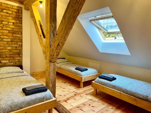 a attic bedroom with two beds and a skylight at Svētes klubs 