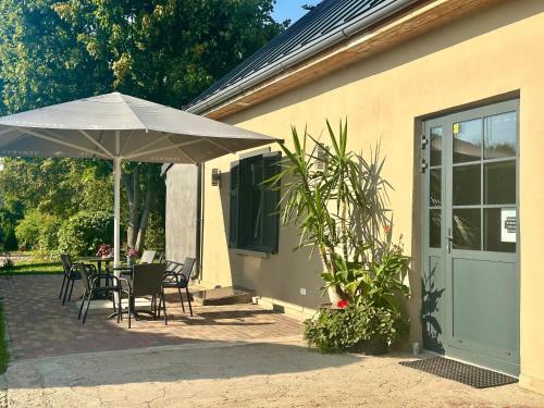 a patio with an umbrella and tables and chairs at Svētes klubs 