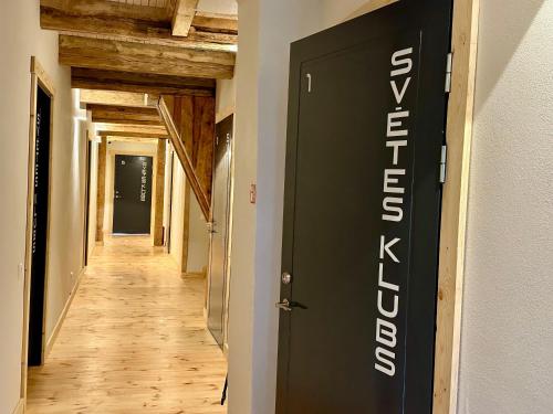 a hallway with a black and white sign on a wall at Svētes klubs 