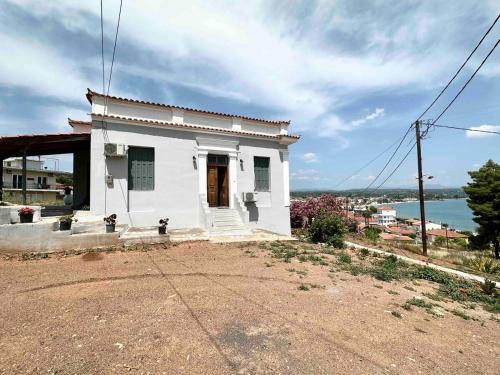 a small white house on the side of a hill at Messenian Style House with Great Views in Petalidhion