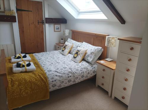 a bedroom with a bed with pillows and a window at Olde Farm Holiday Cottages in Banham