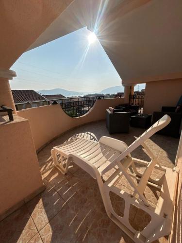 a white chair sitting on a balcony with a view at Apartmani Relax D in Tivat