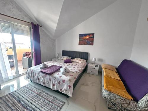 a small bedroom with a bed and a window at Apartmani Relax D in Tivat