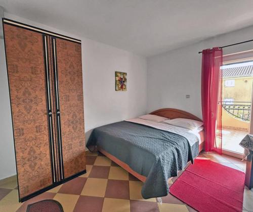 a bedroom with a bed and a large window at Apartmani Relax D in Tivat