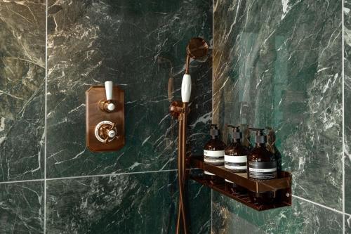 - une salle de bains avec des bouteilles de vin sur un mur dans l'établissement La suite de luxe Saint Germain, à Paris